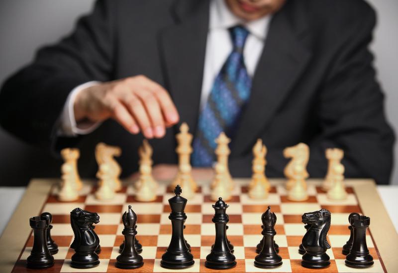 Man in suit behind chessboard