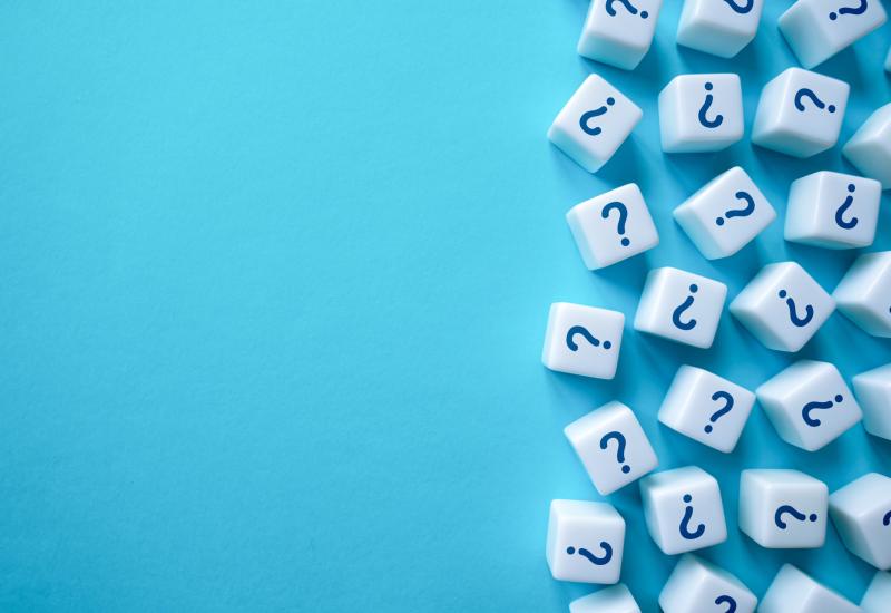Cubes with question marks on against blue background